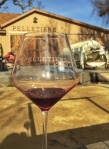 Looking through a Pelletiere Winery wine glass towards the barn door at the winery